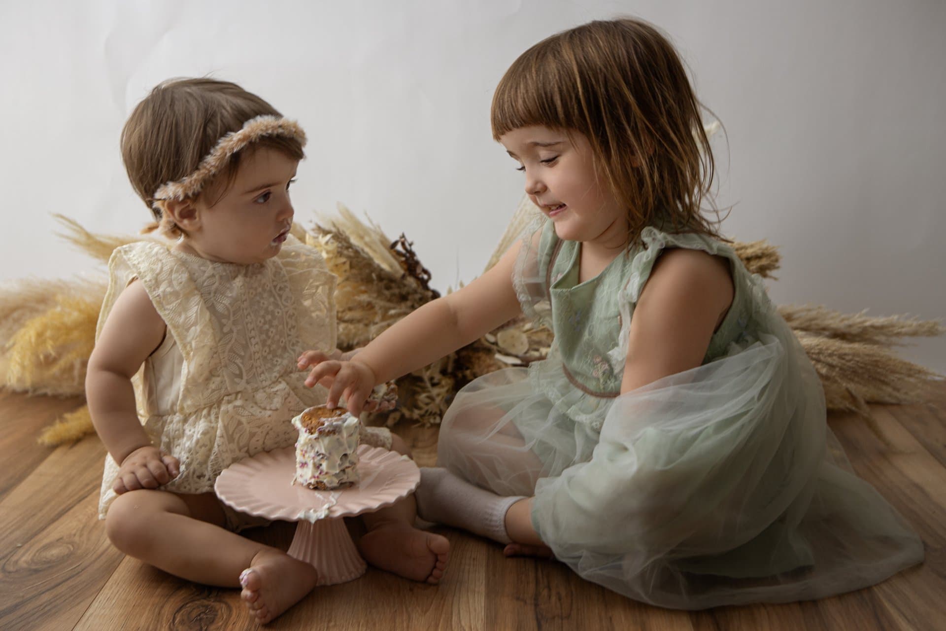 Happy baby splashing in a warm bath after a cake smash session